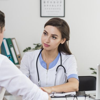 A doctor listening to a patient during a consultation