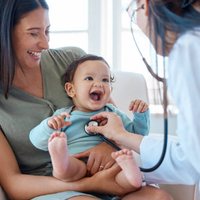 A happy baby at a check-up with mom
